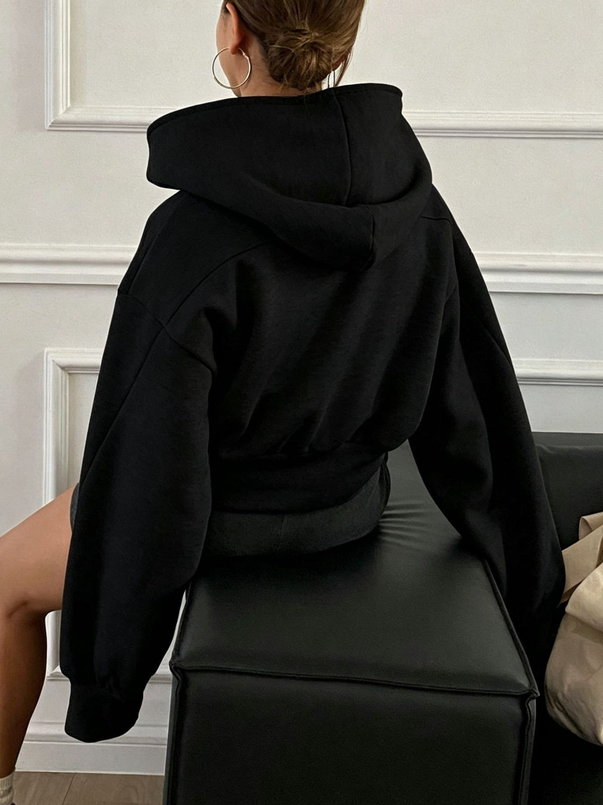 Women's oversized cropped black hooded jacket with long sleeves and front zip