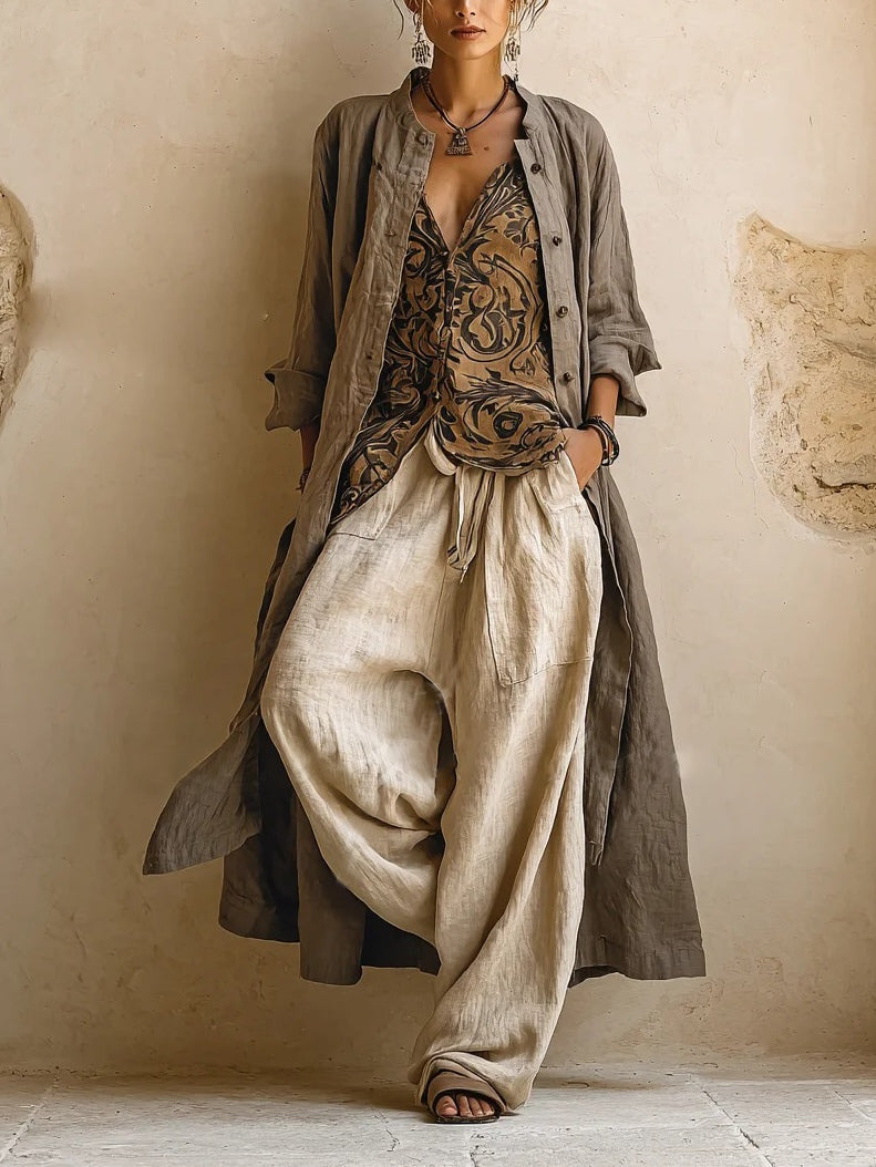 Woman wearing a beige three-piece outfit with printed V-neck top, long cardigan and wide-leg trousers