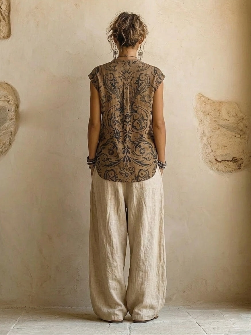 Woman wearing a beige three-piece outfit with printed V-neck top, long cardigan and wide-leg trousers