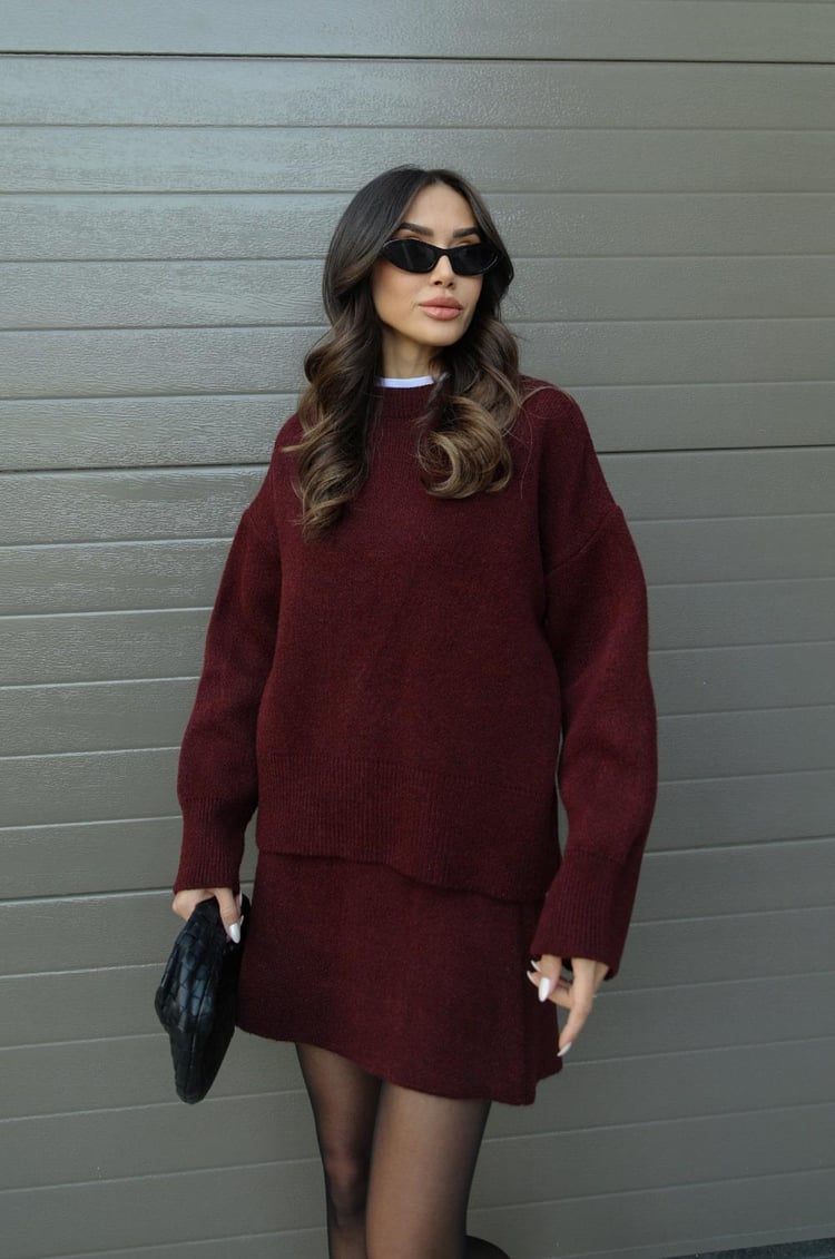 Woman wearing a plain knitted jumper and mini skirt set