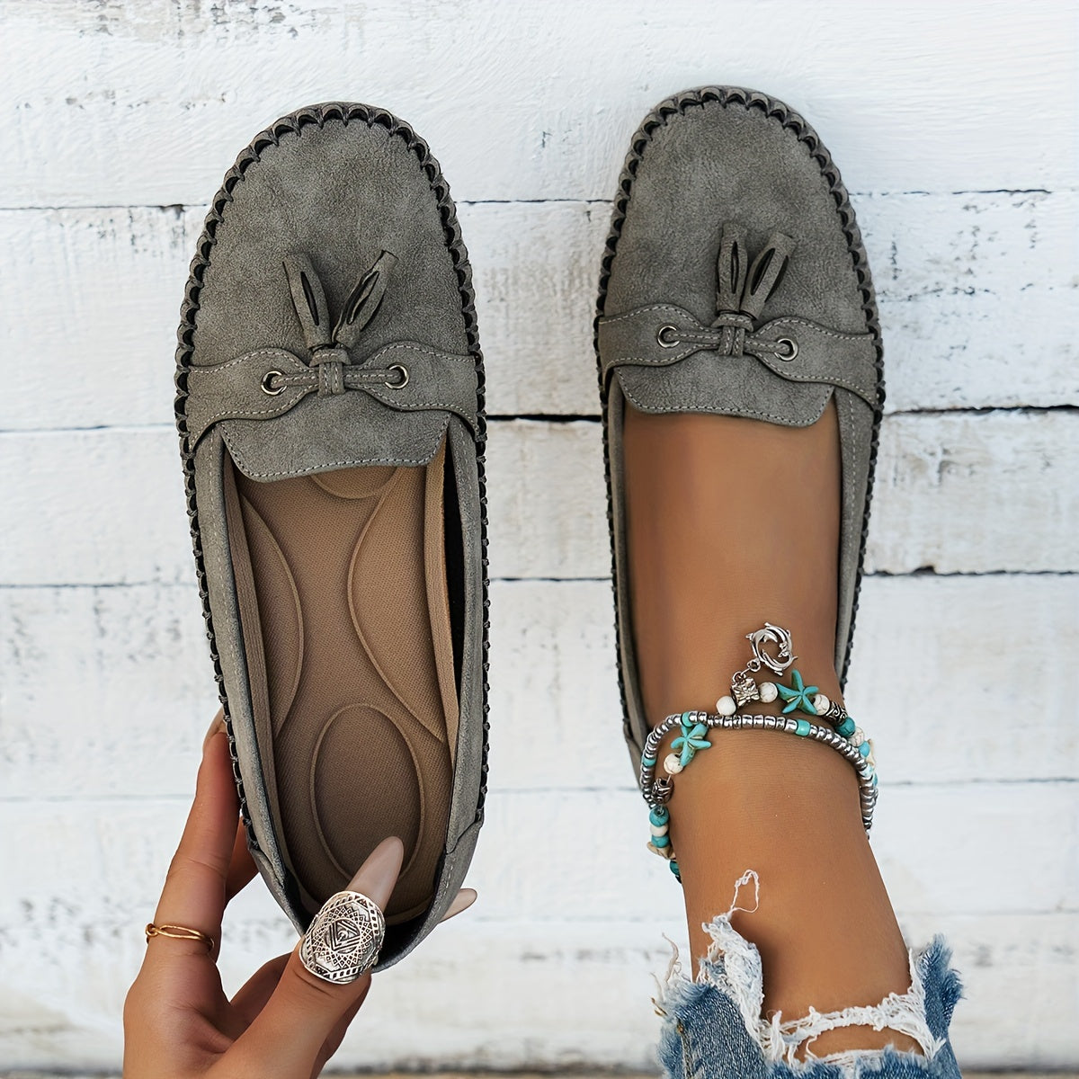 Women's flat loafers with front tassels, decorative lacing and stitched edging