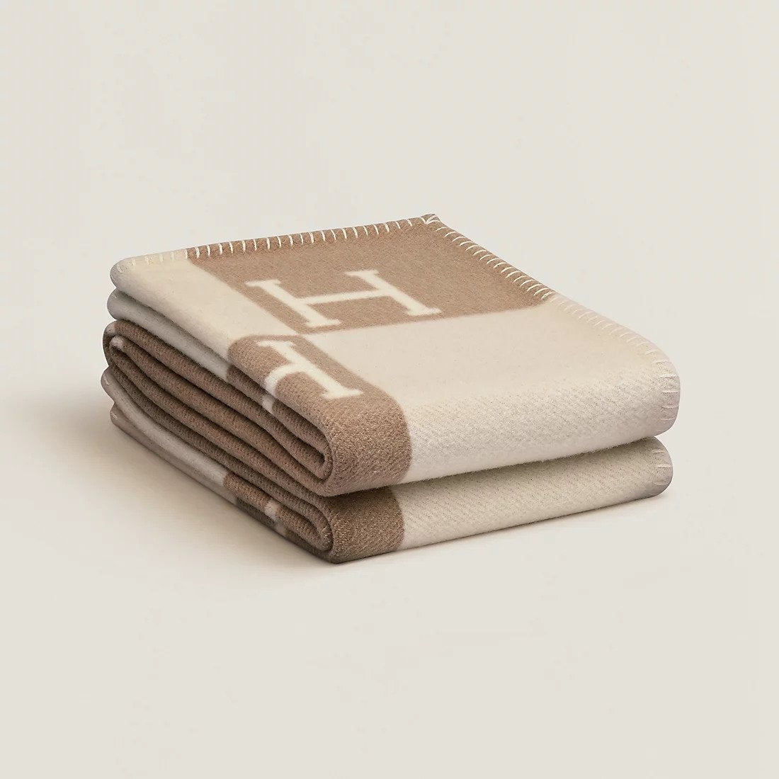Folded rectangular throw blanket with contrasting block pattern and letter motifs