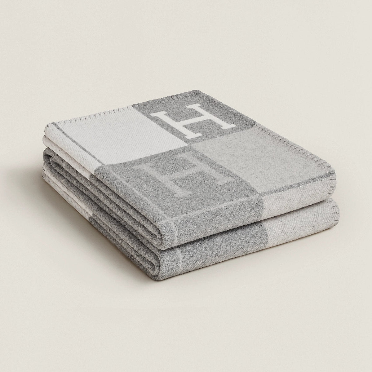 Folded rectangular throw blanket with contrasting block pattern and letter motifs