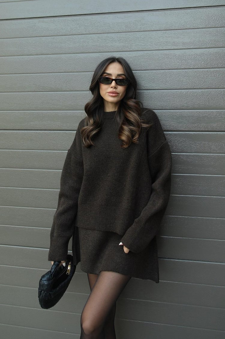 Woman wearing a plain knitted jumper and mini skirt set
