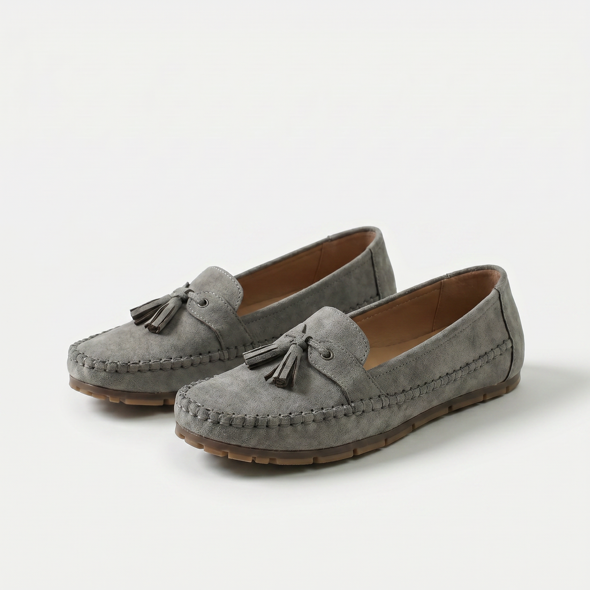 Women's slip-on tassel loafers with rounded moc toes and flat textured soles