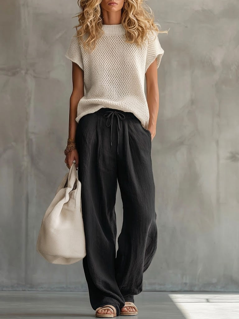 Woman wearing a knitted short-sleeve top with wide-leg drawstring trousers