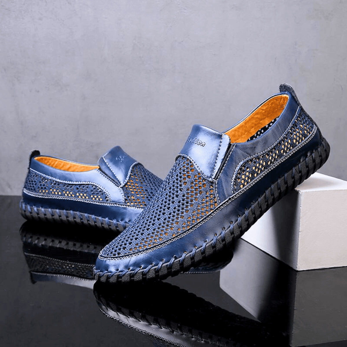 Men's textured slip-on loafer with perforated panels, stitched trim and black flat sole