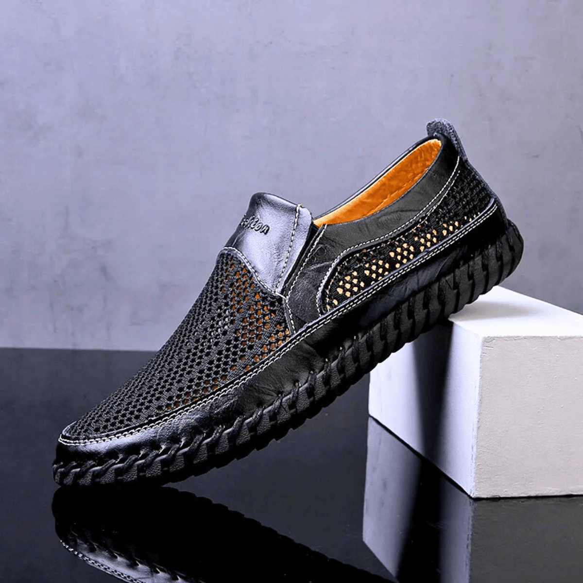 Men's textured slip-on loafer with perforated panels, stitched trim and black flat sole