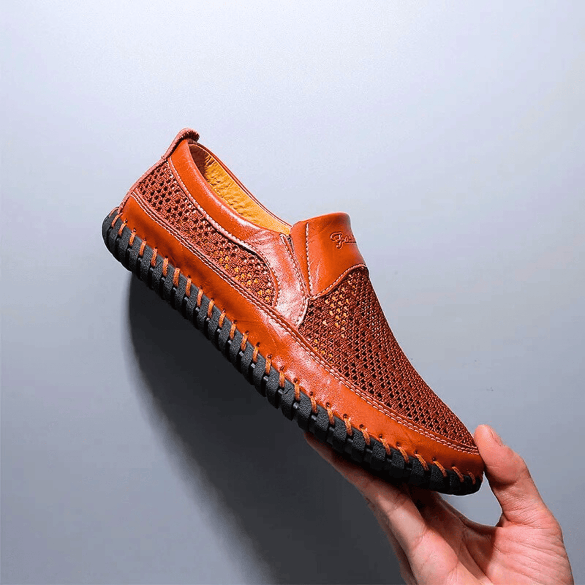 Men's textured slip-on loafer with perforated panels, stitched trim and black flat sole