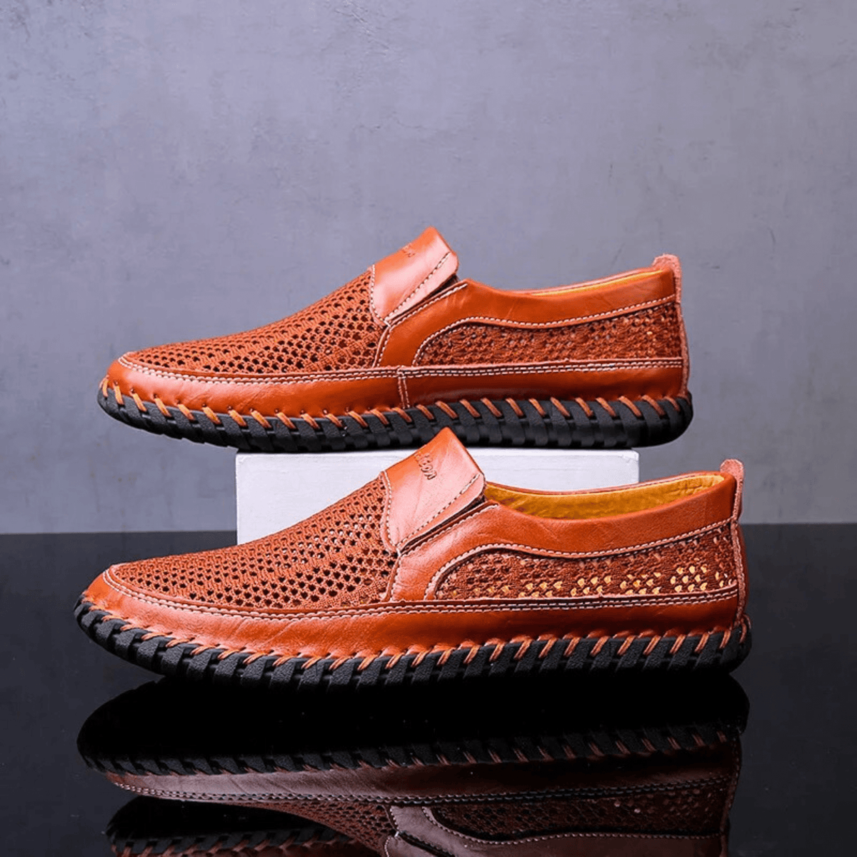 Men's textured slip-on loafer with perforated panels, stitched trim and black flat sole