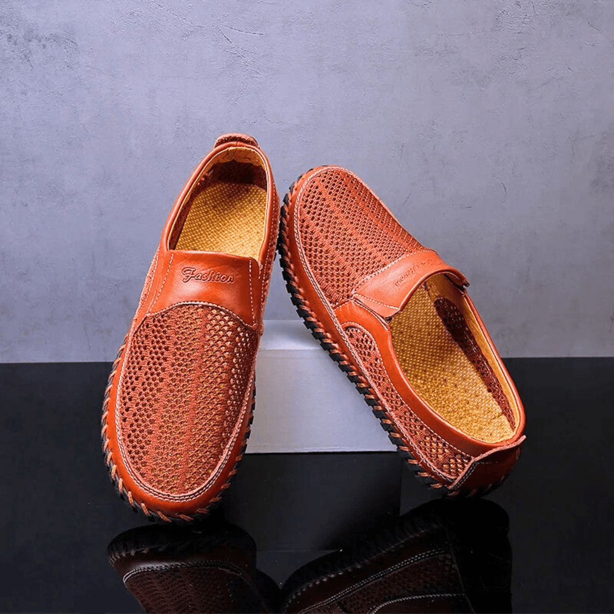 Men's textured slip-on loafer with perforated panels, stitched trim and black flat sole