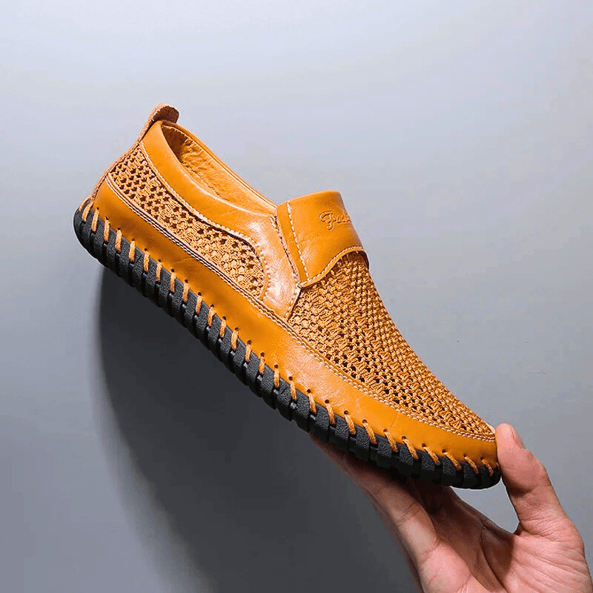 Men's textured slip-on loafer with perforated panels, stitched trim and black flat sole