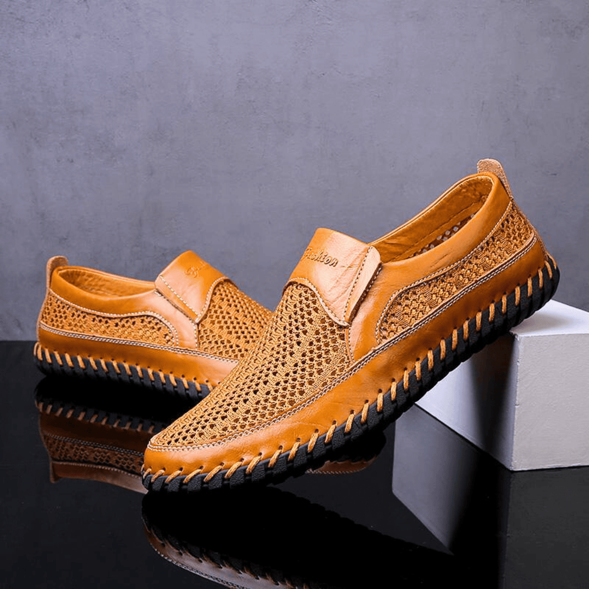 Men's textured slip-on loafer with perforated panels, stitched trim and black flat sole